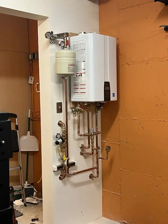 Plumbing technician inspecting water heater connections in Anthony